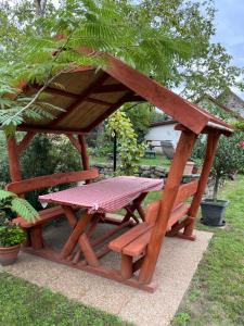 a picnic table and a table and a bench at Öregporta Vendégház in Bazsi