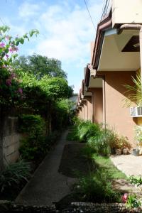 a walkway next to a building with flowering plants at Villa Solaj Dumaguete in Aganan