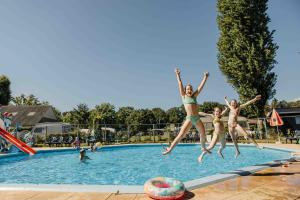 drie meisjes springen in een zwembad bij Recreatiepark Den Blanken in Neede +25 foto's