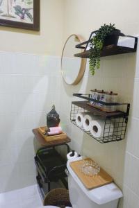 a bathroom with a toilet and shelves on the wall at Villa Solaj Dumaguete in Aganan +63 photos