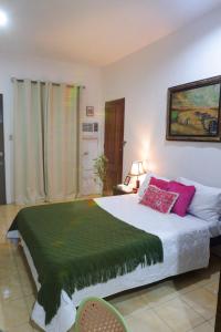 a bedroom with a large bed with red pillows at Villa Solaj Dumaguete in Aganan