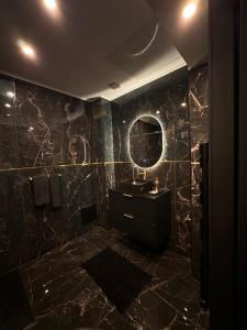 ein schwarzes Badezimmer mit Waschbecken und Spiegel in der Unterkunft Spa2luxe - La Montana in Saint-Quentin + 13 Fotos