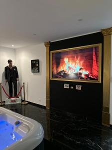 Ein Mann steht in einem Raum mit Kamin in der Unterkunft Spa2luxe - La Montana in Saint-Quentin