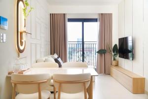 a white dining room with a table and chairs at KNV Apartment in Thu Dau Mot