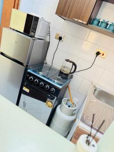 a small kitchen with a stove and a microwave at Elite Haven in Masaka