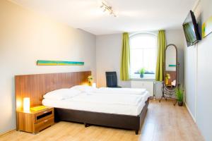 ein Schlafzimmer mit einem großen Bett und einem Fernseher in der Unterkunft Hotel Dampfmühle in Neukirchen-Vluyn