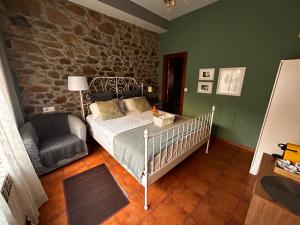 a bedroom with a bed and a chair in it at Hostal Casa San Nicolas in Molinaseca