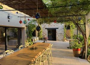 an outdoor patio with a wooden table and chairs at Maison Bruno Di Salvio in Les Vans