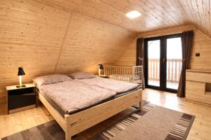 a bedroom with a bed in a wooden room at Chata pri Kaštieli - 2 E-bikes in Necpaly