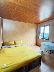 a bedroom with a large yellow bed and a window at Hostel 405 Sa Pa in Sapa