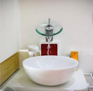 a bathroom with a bowl sink with a water fountain at Mariposa Grumo in Grumo Appula +23 photos