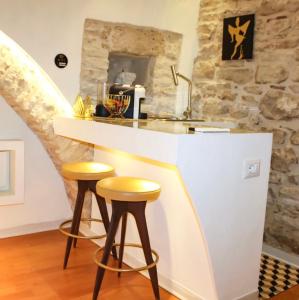 a kitchen with a counter and two stools at a bar at Mariposa Grumo in Grumo Appula