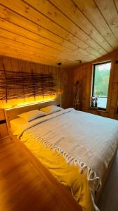 a large bed in a room with a wooden ceiling at Trava Bungalow in Korostov
