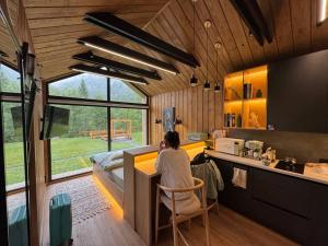 a woman sitting at a counter in a kitchen at Trava Bungalow in Korostov