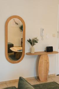 a mirror on a wall with a table and a chair at Olive Aura in Mytilene +24 photos