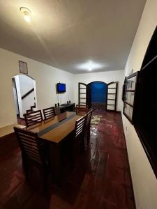 a living room with a dining room table and chairs at Casa Espaçosa em Unamar in Cabo Frio