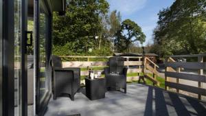 a patio with chairs and a table and a fence at Newby Bridge Country Caravan Park in Newby Bridge +167 photos