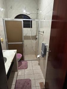 a bathroom with a shower and a toilet and a sink at Casa Espaçosa em Unamar in Cabo Frio +17 photos