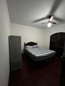 a bedroom with a bed and a ceiling fan at Casa Espaçosa em Unamar in Cabo Frio