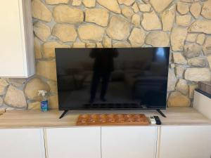 a tv sitting on top of a counter with a stone wall at Harran Kümbet Otel in Harran +3 photos