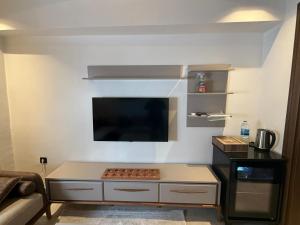 a living room with a kitchen with a flat screen tv at Harran Kümbet Otel in Harran