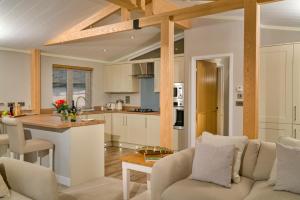 a kitchen and living room with a couch and a table at Finest Retreats - Heron Luxury Lodge in Bourn