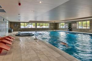a large swimming pool in a building with a large swimming pool at Finest Retreats - Heron Luxury Lodge in Bourn