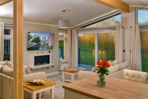 a living room with a couch and a tv at Finest Retreats - Heron Luxury Lodge in Bourn
