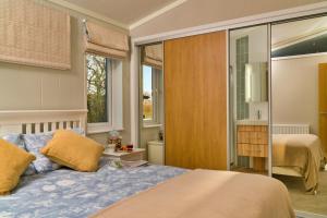 a bedroom with a bed and a window at Finest Retreats - Heron Luxury Lodge in Bourn +17 photos