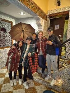 a group of people posing for a picture with an umbrella at La Kasbah Salam Hostel in Fez +64 photos