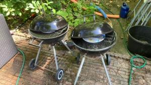 two bbqurgers are sitting on the ground at Klein Nieuwe Wegen in Ons Belang