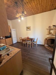 Eine Küche und ein Esszimmer mit Tisch und Kamin in der Unterkunft Giorgoula house in Koilani