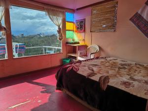 a bedroom with a bed and a window with a view at Casa de Yolanda en Uros in Puno