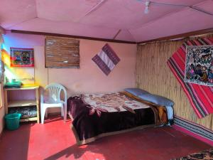 a bedroom with a bed and a desk in a room at Casa de Yolanda en Uros in Puno