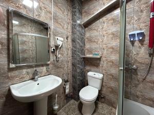a bathroom with a sink and a toilet and a mirror at GuestHouse Old Avlabari in Tbilisi City