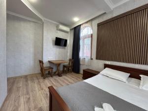 a bedroom with a bed and a table in it at GuestHouse Old Avlabari in Tbilisi City