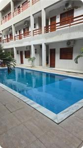 a large blue swimming pool in front of a building at Flat 11 Condomínio Ibiapaba Camocim in Camocim