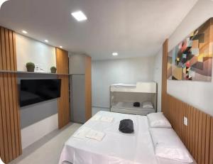 a small room with a bed with white sheets at Flat 11 Condomínio Ibiapaba Camocim in Camocim