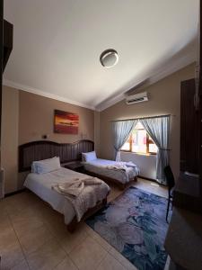 a bedroom with two beds and a window at Goba Lodge & Rest Camp in Gobabis +31 photos