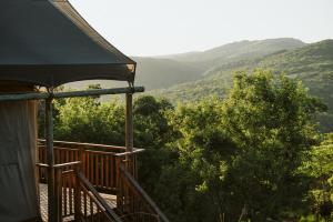 a balcony of a house with a view of the mountains at Matatane Camp - Babanango Game Reserve in Babanango