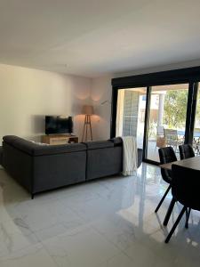a living room with a couch and a table and chairs at Résidence Les Jardins du Piale in Bonifacio