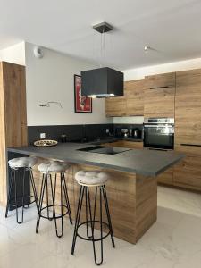 a kitchen with a island with bar stools in it at Résidence Les Jardins du Piale in Bonifacio