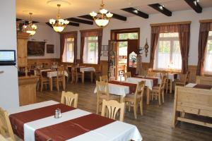 Hotel Encian في رايتسكي تيبليتسه: مطعم فيه طاولات وكراسي في الغرفة