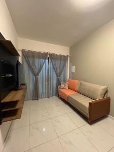 a living room with a couch and a flat screen tv at Beautiful Cozy Beach House Accommodation in Guaratuba