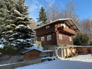 a house in the snow with a tree at Chata Na Mechu in Dolní Podluží