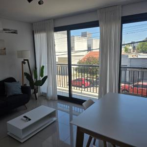 a living room with a table and a large window at LaFaldaStayBahia - Confort y Bienestar garantizado in Bahía Blanca