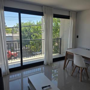 a dining room with a view of a balcony at LaFaldaStayBahia - Confort y Bienestar garantizado in Bahía Blanca