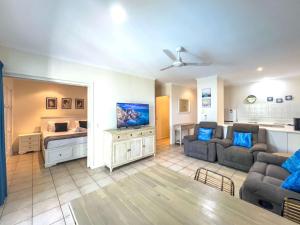 a living room with a couch and a tv at Escape To Mango House in Airlie Beach +50 photos