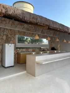 a stone building with a white refrigerator and a counter at Apartamento A03 - Curimã in Passo de Camarajibe