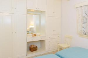 a bedroom with white cabinets and a mirror at Folia in Agia Marina
